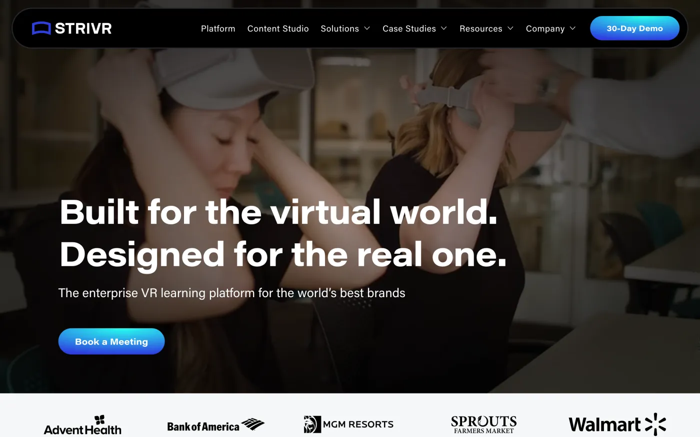 The Strivr homepage: a dark full-bleed photo of two people putting on VR headsets, headline Built for the virtual world. Designed for the real one, with a customer logo bar beneath.